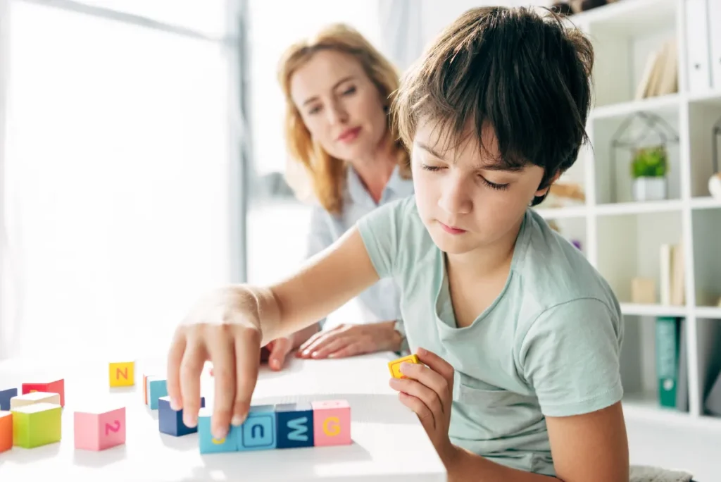 Bambino dislessico si esercita con una specialista pedagogica esperta in DSA
