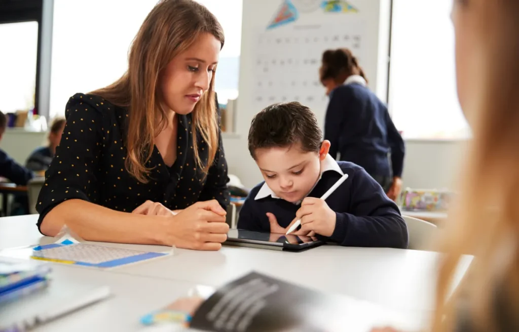 Pedagogista lavora insieme ad insegnante per istruzione bambino down scuola primaria